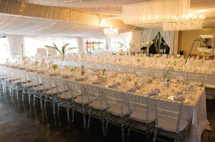 A large room with tables and chairs set up for a wedding.