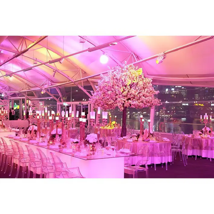 A pink tent with tables and chairs set up for a wedding.