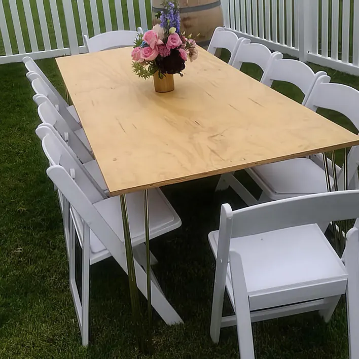 A white table with chairs and flowers on it.