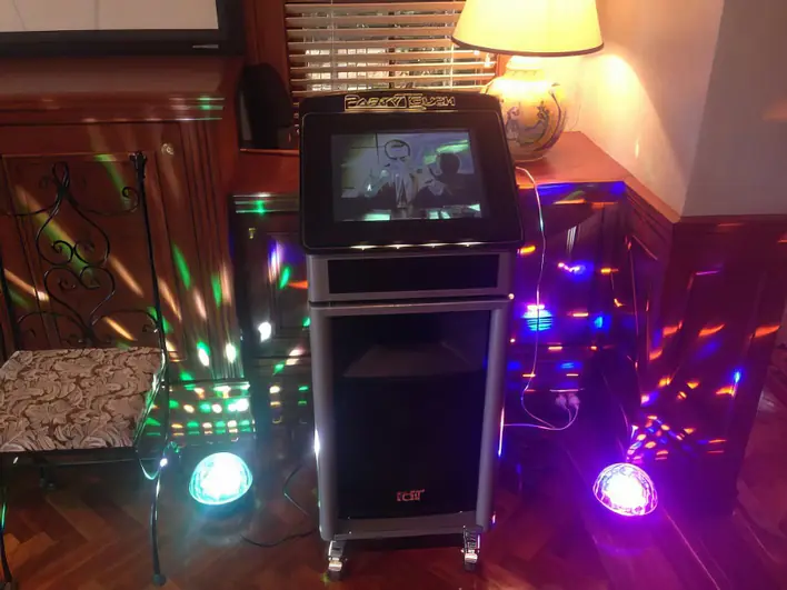 A karaoke machine in a room with colorful lights.