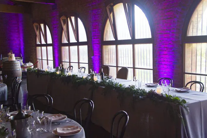 A wedding reception set up with purple lighting.