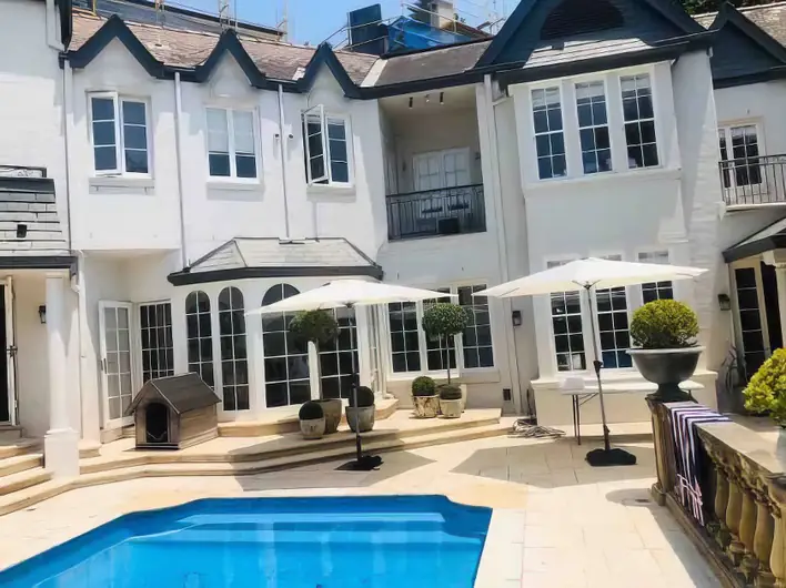 A house with a swimming pool and umbrellas.