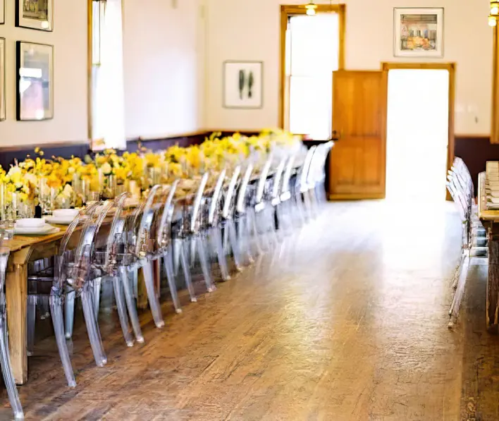 A long table is set up with yellow chairs.