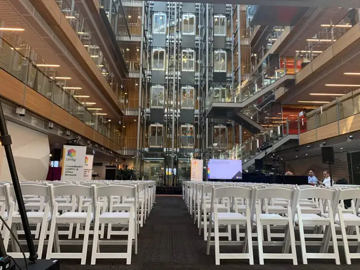 A large auditorium with white chairs and a stage.