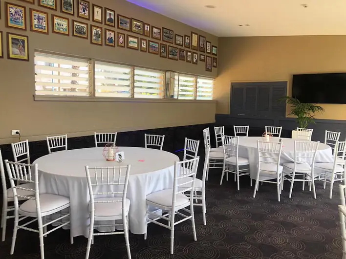 A room with tables and chairs set up for a party.