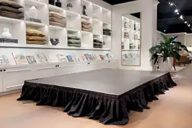An indoor black stage set up in a display centre.