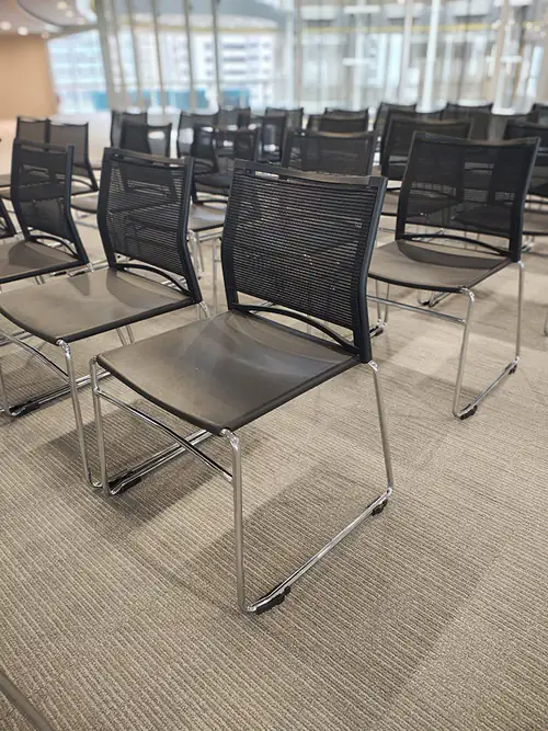 Black plastic conference chairs lined up and ready for a meeting