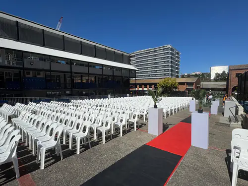 Hundreds of white plastic chairs set up for a major outdoor event