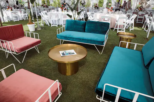 White sofa lounges surrounding a brass table