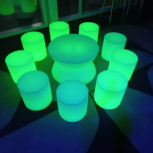 A green glow table surrounded by green glowing stools