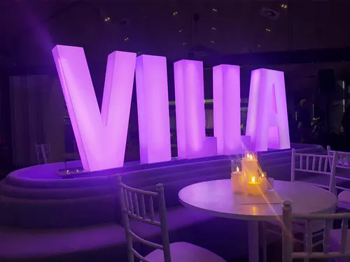 Large pink glow letters that spell 'VILLA'