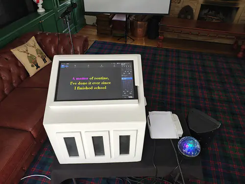 A hired karaoke machine all set up, ready to go with the projector screen and lyrics on the screen