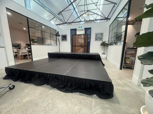 Modern office presentation stage platform with black skirting inside a contemporary commercial workspace