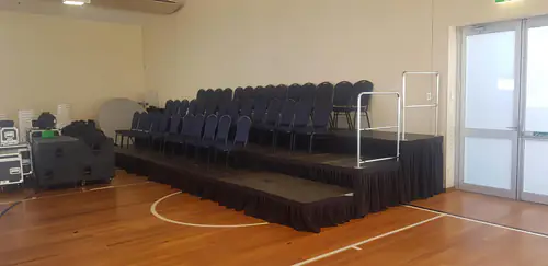 Indoor stage platform with black skirting set up for a presentation or speaking event