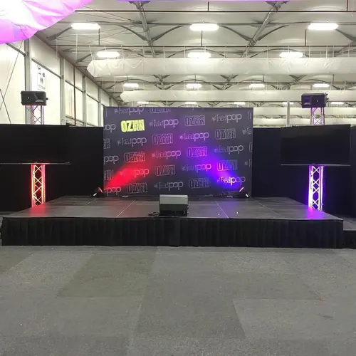 Portable stage platform system with black skirting arranged in an event space