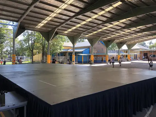 Raised stage platform with black skirting set up in a function or event space