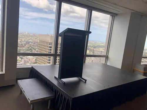 Low height stage platform with black skirting set up for a presentation or small event