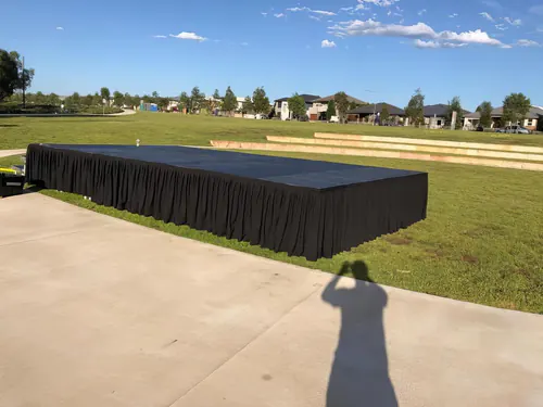 Modular stage platform with black skirting arranged for a professional event setup