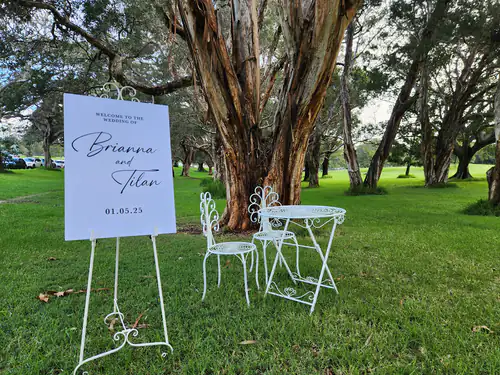 A signing table and chair set next to an easel with a sign