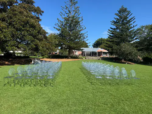 Over 100 Victorian ghost chairs set up for a wedding in a park