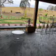 Black Arrow 3 Seater Sofa on a patio with a stunning view of a field.