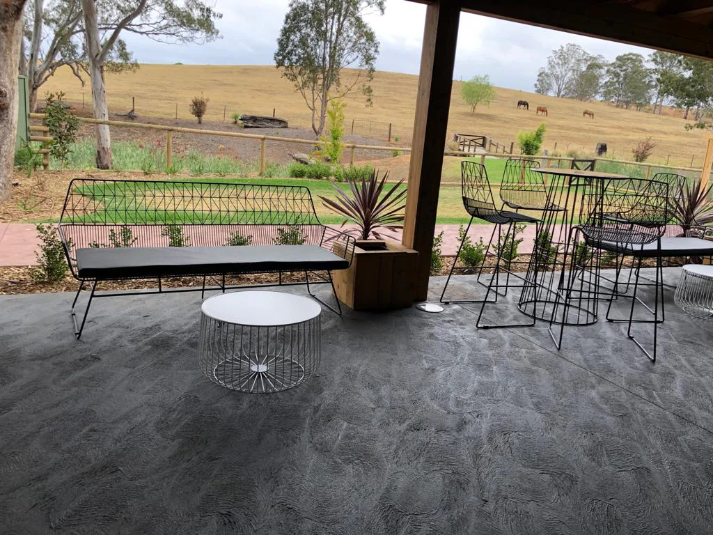 Black Arrow 3 Seater Sofa on a patio with a stunning view of a field.