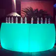 A curved green LED bar with glowing bottles on top.
