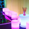 A vibrant space adorned with shimmering glow cylinder seats for hire, brightening the room with an array of colorful lights.