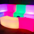 A Glow Lounge Suite Hire in a dark room set with colorful LED sofas.