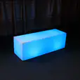A blue LED cube sitting on top of a carpet, emitting a mesmerizing glow.