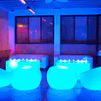 A group of blue Glow Sphere Chairs in a room.