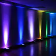 A room with Par Can lights casting vibrant colors in the background.