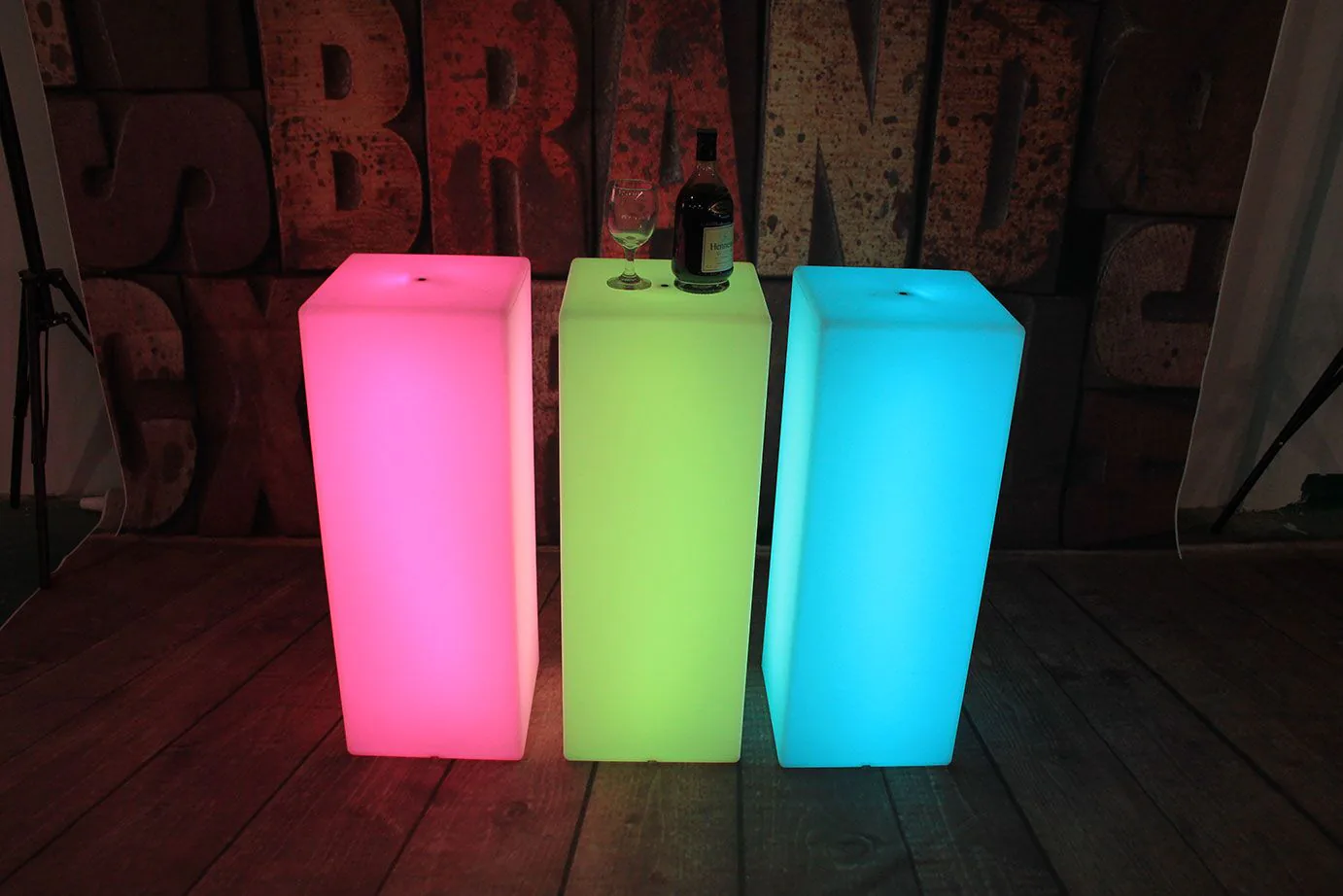 Three lighted cubes, with a glowing effect, placed on a wooden floor.