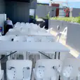 A plastic table and chairs are set up on a balcony.