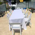 A white plastic table and chairs on a balcony.