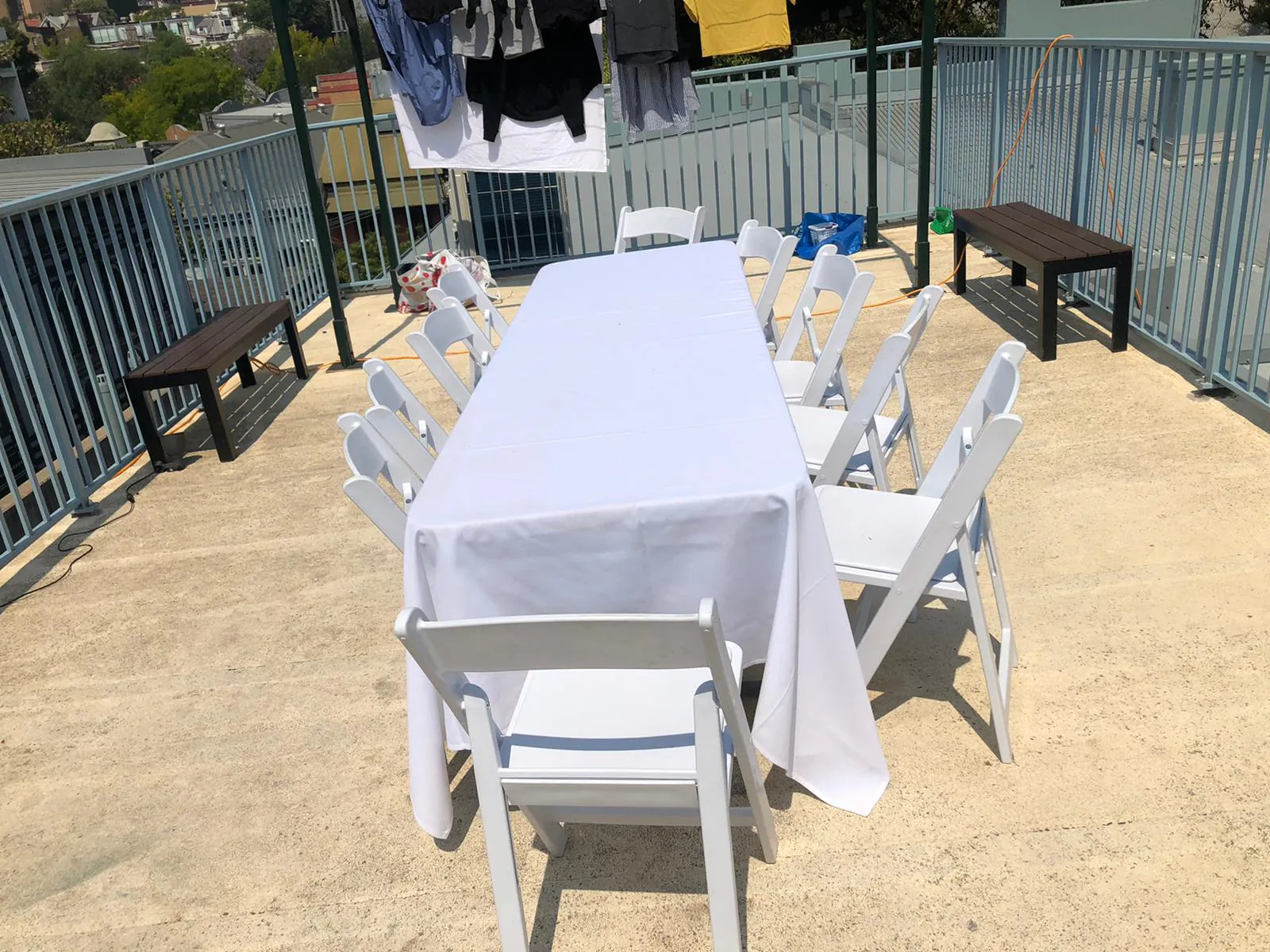 A white plastic table and chairs on a balcony.