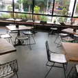 An empty restaurant with Black Wire Chairs and tables.