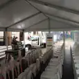 An 8m x 21m white tent with rows of white chairs.