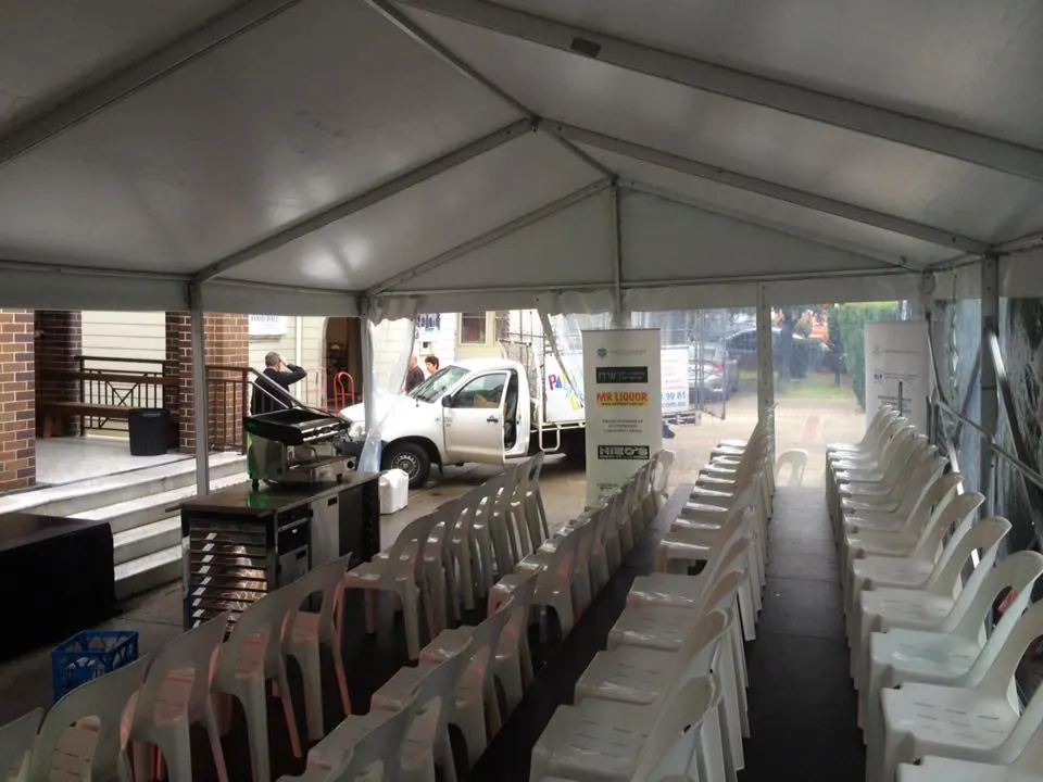 An 8m x 21m white tent with rows of white chairs.