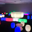 A room full of colorful glow stools and tables for hire.