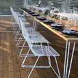 A white table and chairs are set up in a tent for White Chair Hire.