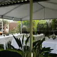 A 6m x 18m white tent with tables and chairs set up in a backyard.