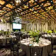 A large room with tables and chairs set up for an event, including Black Tiffany Chair Hire.