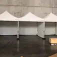 Three 3mx3m pop up marquees with walls on three sides set up in a warehouse.