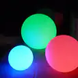 A group of colorful 40cm lighted balls on a concrete floor.