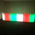 A vibrant LED bar, glowing with red, green, and blue hues, illuminating the room.