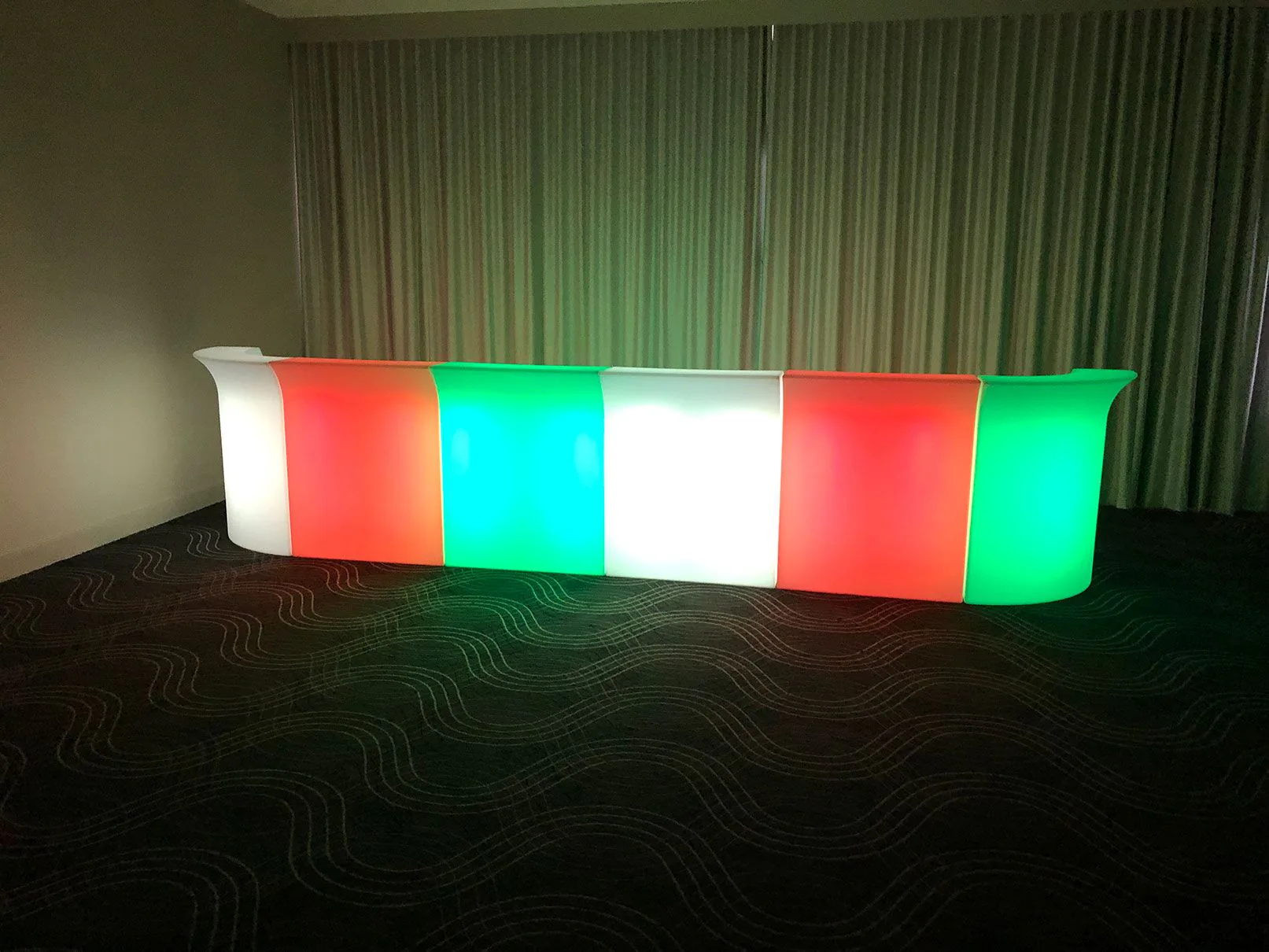 A vibrant LED bar, glowing with red, green, and blue hues, illuminating the room.