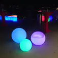 A group of colorful lighted Glow Spheres, measuring 60cm in diameter, placed on a deck.