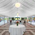 A 10m x 12m framed marquee tent with a table and chairs.