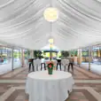 A 6m x 9m white tent with a table and chairs.